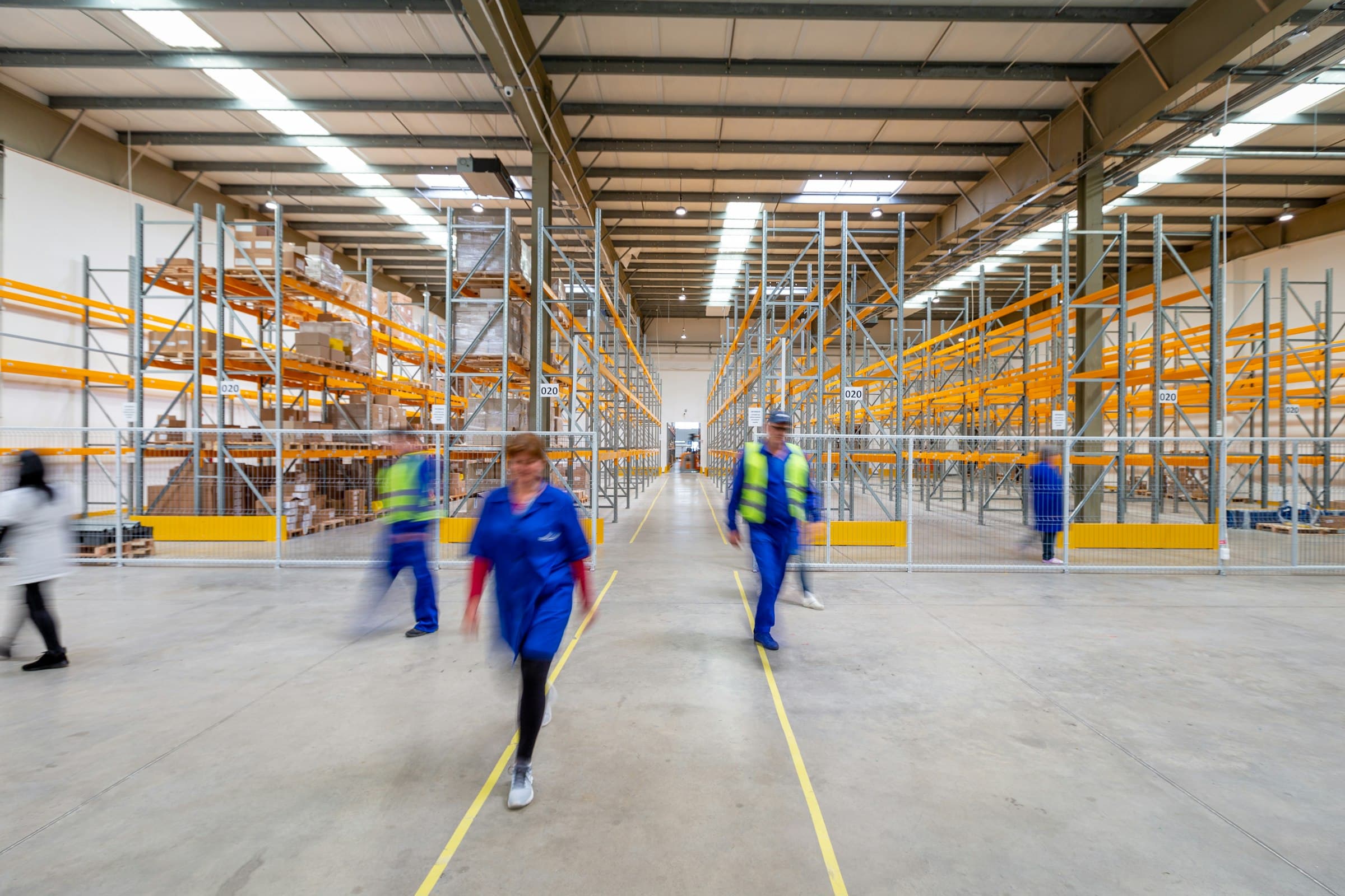 Staff walking the main aisle of a distribution center